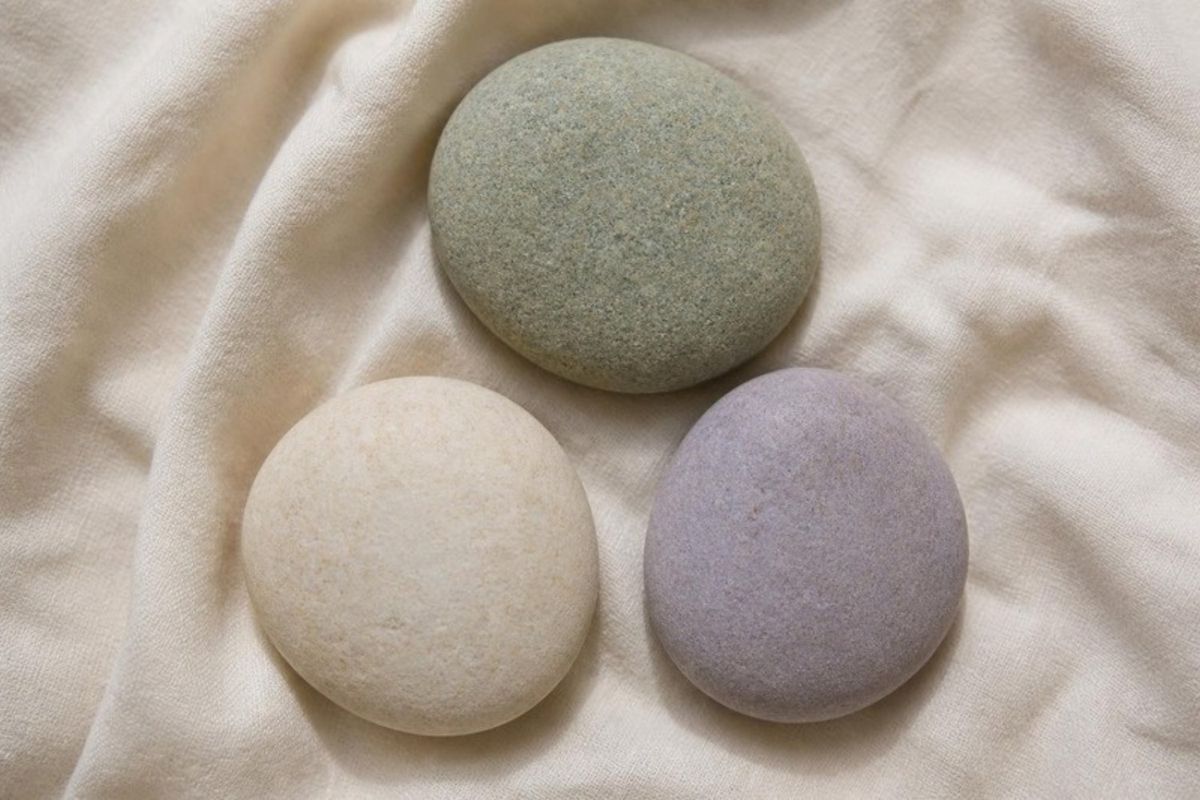 Three smooth stones on cream linen