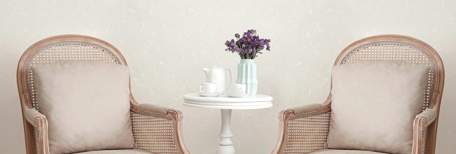 Two armchairs facing each other beside a small table with tea